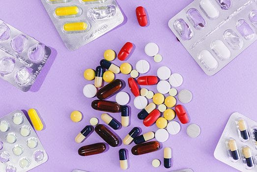 Pills and blisters on purple background